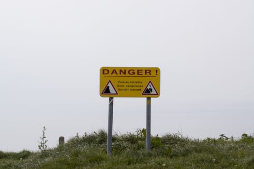 Warning sign for falling stones at the coast of France