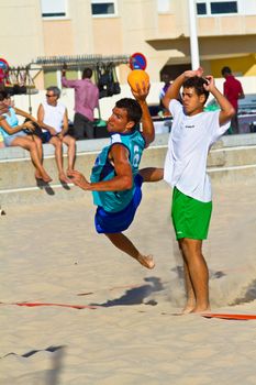 CADIZ, SPAIN - JULY 19: Unidentified players compete in a match between BMPY LAM Chiclana and Los Legendarios in the 19th league of beach handball of Cadiz on July 19, 2011 in Cadiz, Spain