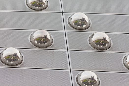 Mirror spheres as part of modern building facade reflect big city scene, Germany, Europe