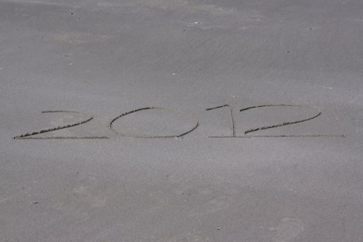 The year 2012 written in sand along the coast