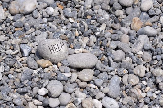 Help written on flintstone on the beach along the coast of Normandie in France