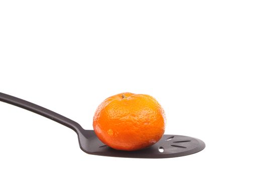 Tangerine on a spoon against a white background