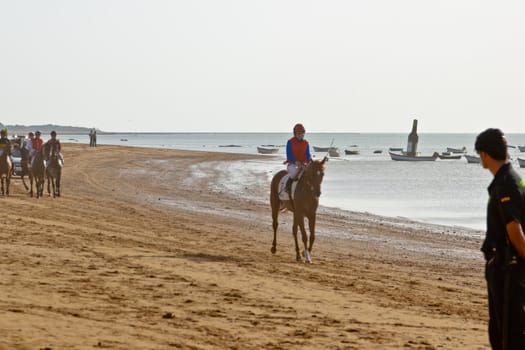 SANLUCAR DE BARRAMEDA, CADIZ, SPAIN - AUGUST 10: Unidentified riders at the start of race horses on Sanlucar de Barrameda beach on August 10, 2011 in Sanlucar de Barrameda, Cadiz, Spain.
