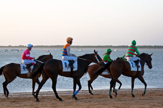 SANLUCAR DE BARRAMEDA, CADIZ, SPAIN - AUGUST 10: Unidentified riders at the start of race horses on Sanlucar de Barrameda beach on August 10, 2011 in Sanlucar de Barrameda, Cadiz, Spain.