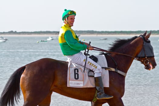 SANLUCAR DE BARRAMEDA, CADIZ, SPAIN - AUGUST 10: Unidentified rider at the start of race horses on Sanlucar de Barrameda beach on August 10, 2011 in Sanlucar de Barrameda, Cadiz, Spain.