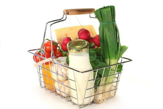 Shopping basket with milk, cheese and mixed vegetables