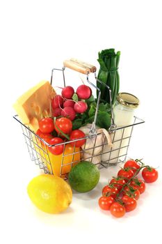 Shopping basket with milk, cheese and mixed vegetables