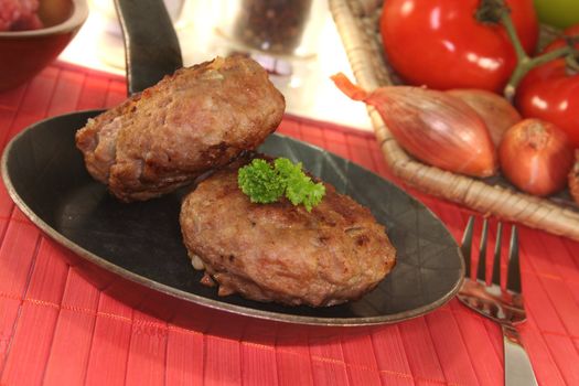 fried meatballs in a pan with fresh parsley