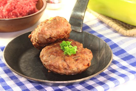 fried meatballs in a pan with fresh parsley