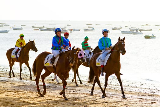 SANLUCAR DE BARRAMEDA, CADIZ, SPAIN - AUGUST 10: Unidentified riders at the start of race horses on Sanlucar de Barrameda beach on August 10, 2011 in Sanlucar de Barrameda, Cadiz, Spain.