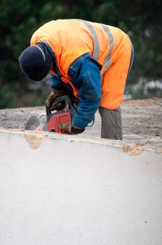 Workman Using Jackhammer on Roof of Building