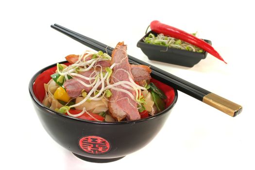 Duck breast with fried noodles, fresh vegetables and radish sprouts