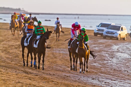SANLUCAR DE BARRAMEDA, CADIZ, SPAIN - AUGUST 10: Unidentified riders at the start of race horses on Sanlucar de Barrameda beach on August 10, 2011 in Sanlucar de Barrameda, Cadiz, Spain.