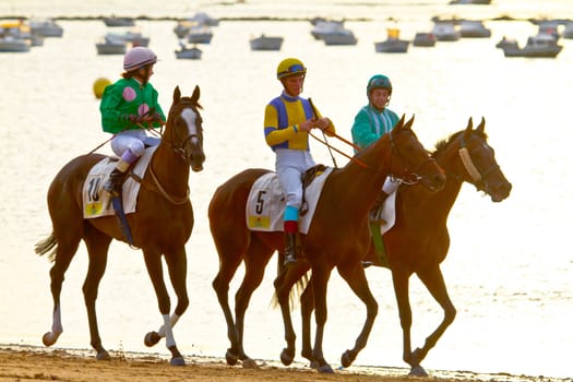 SANLUCAR DE BARRAMEDA, CADIZ, SPAIN - AUGUST 11: Unidentified riders at the start of race horses on Sanlucar de Barrameda beach on August 11, 2011 in Sanlucar de Barrameda, Cadiz, Spain.