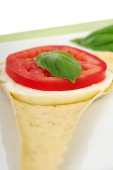 Appetizer: Mozzarella cheese, tomato slice and basil leaf on Crocantini (Selective Focus)