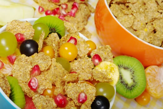 Fruits and Cereals in colorful bowls on tablecloth