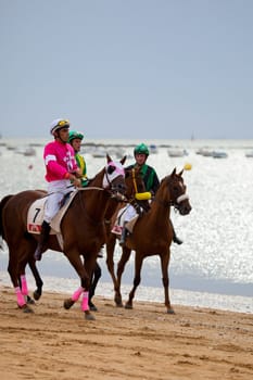 SANLUCAR DE BARRAMEDA, CADIZ, SPAIN - AUGUST 07: Unidentified riders at the start of race horses on Sanlucar de Barrameda beach on  August 07, 2010 in Sanlucar de Barrameda, Cadiz, Spain.
