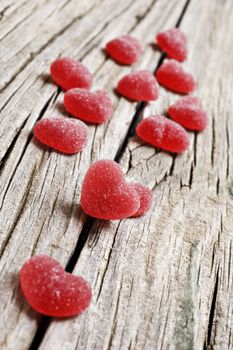 Red heart shaped jelly sweets on a rustic background