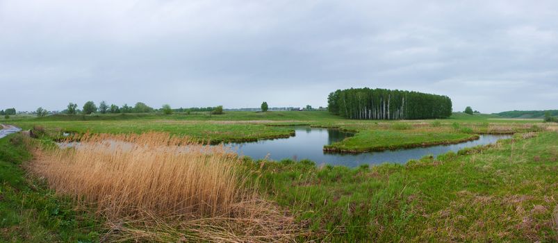 Panorama from the green field and the river