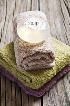 Fresh towels and soap on a rustic wooden surface