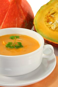 a white Soup cup with fresh pumpkin soup