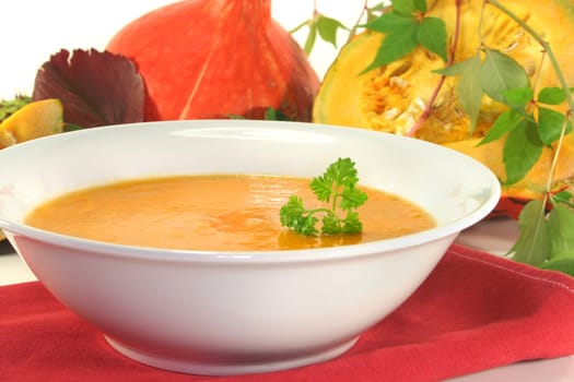 a white plate with fresh pumpkin soup