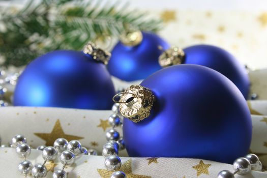blue Christmas balls and pine branches on Christmas fabric