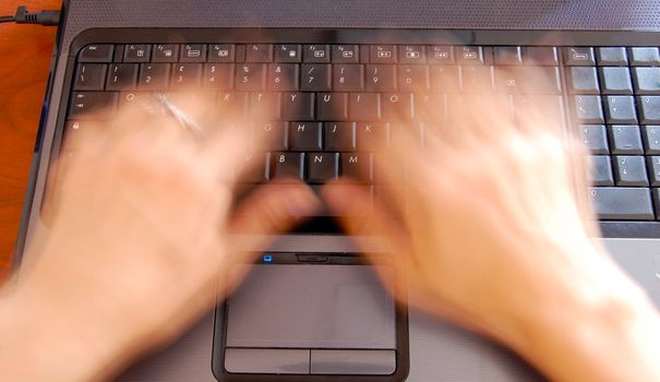female hands over silver computer keyboard working at office desk