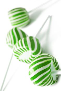 Green and white candy lolly pops on white background