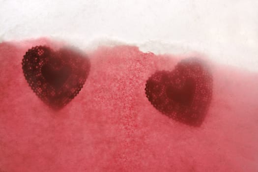 two heart-shaped doilies with textured paper in red, pink and white