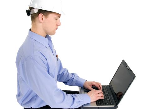 Young construction worker sitting at a laptop computer