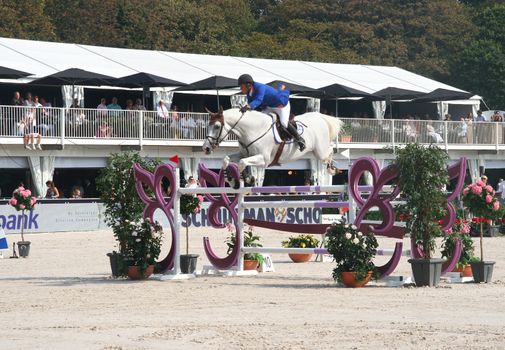 THE HAGUE, HOLLAND - AUGUST 31, 2008: Concours Hippique. Horse clearing a hurdle at the annual horse jumping competition at Westbroek Park.