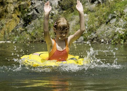 The girl floats on lake with a life buoy