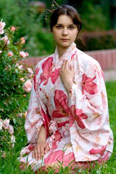 Girl in a pink yukata near rose-bush
