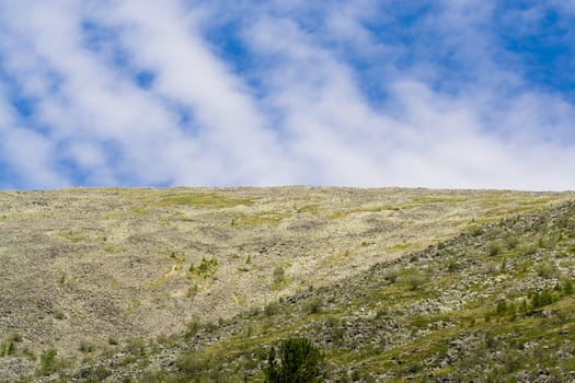 woodless stony mountainside and cloudly sky
