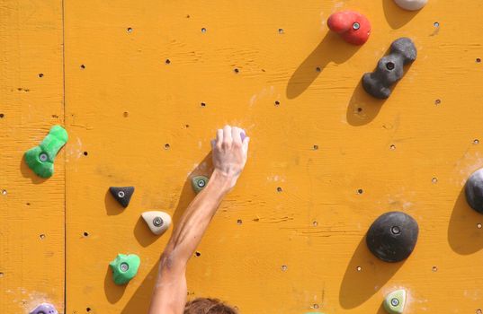 Hand of a climber on a bouldering wall