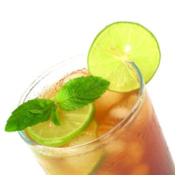 Mint leaf and lime slice on the top of iced tea (Selective Focus, Focus on the mint leaf and the lime slice on the glass rim)