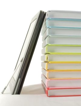 Stack of colorful books and electronic book reader on the white background