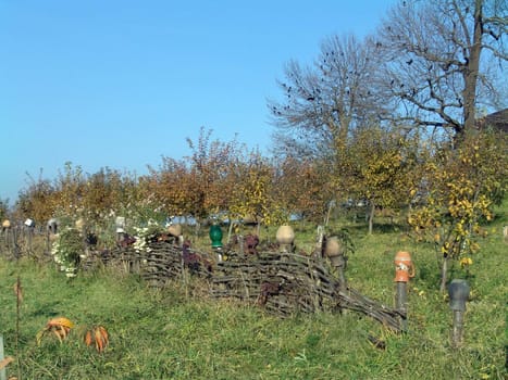 The country old Ukrainian fence, autumn grass and garden