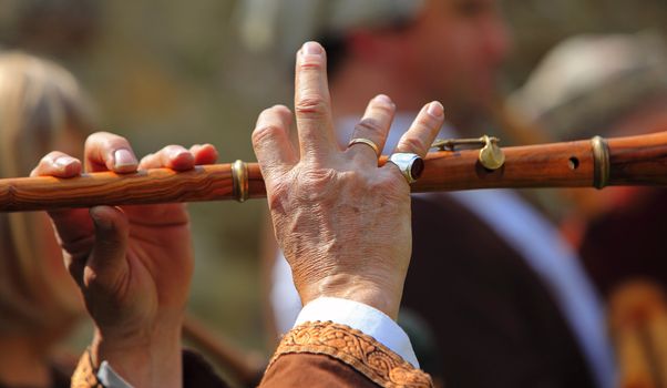  Detail of hands of a flute player during a medieval music performance. 