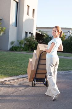 Portrait of an pretty woman with stack of box moving to a new house