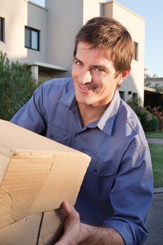 Portrait of man holding cardboard box while shifting to a new home