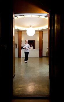 A young female walking through an old functionalism style spa interior
