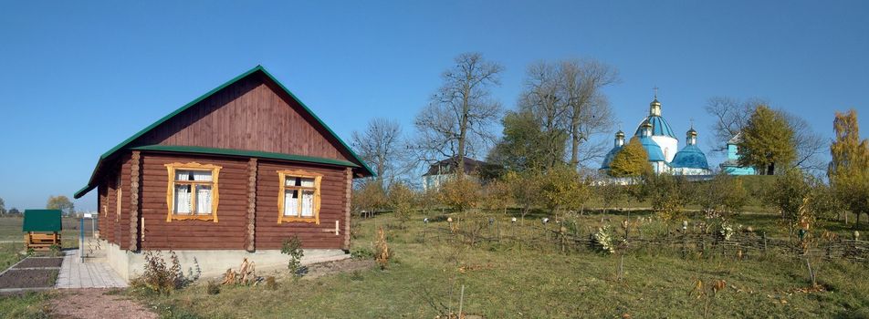 The panoramic photo of country old house and the orthodox church