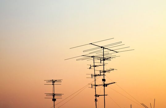 silhouettes of antennas with sunset