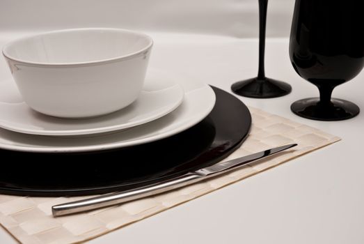 Service plates in black and white, with plate, glasses, cutlery
