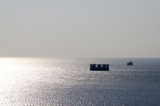 Ship sailing in the gold and silver reflection of the  sunset