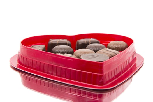 An assortment of chocolates in a heart shaped valentine's day box