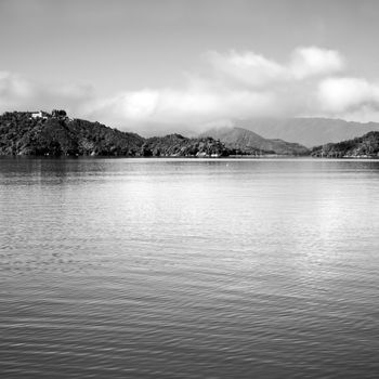 Nature landscape of lake with mountain and water under sky in black and white tone.
