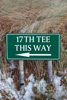 the 17th tee this way sign on an irish golf course in the winters snow